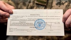 повістка про призов на військову службу в руках людини