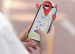 Пошук локації на смартфоні – рука тримає телефон із картою та піном місця, інтерфейс пошуку закладів і геолокації