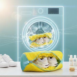 Жовтий ворсистий мішок з кросівками на фоні пральної машини, що ілюструє процес делікатного автоматичного прання взуття.