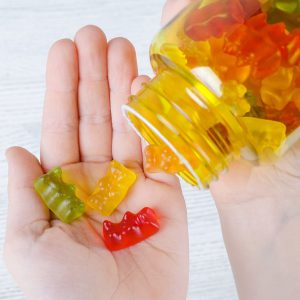 жувальні вітаміни у формі ведмедиків у дитячій руці