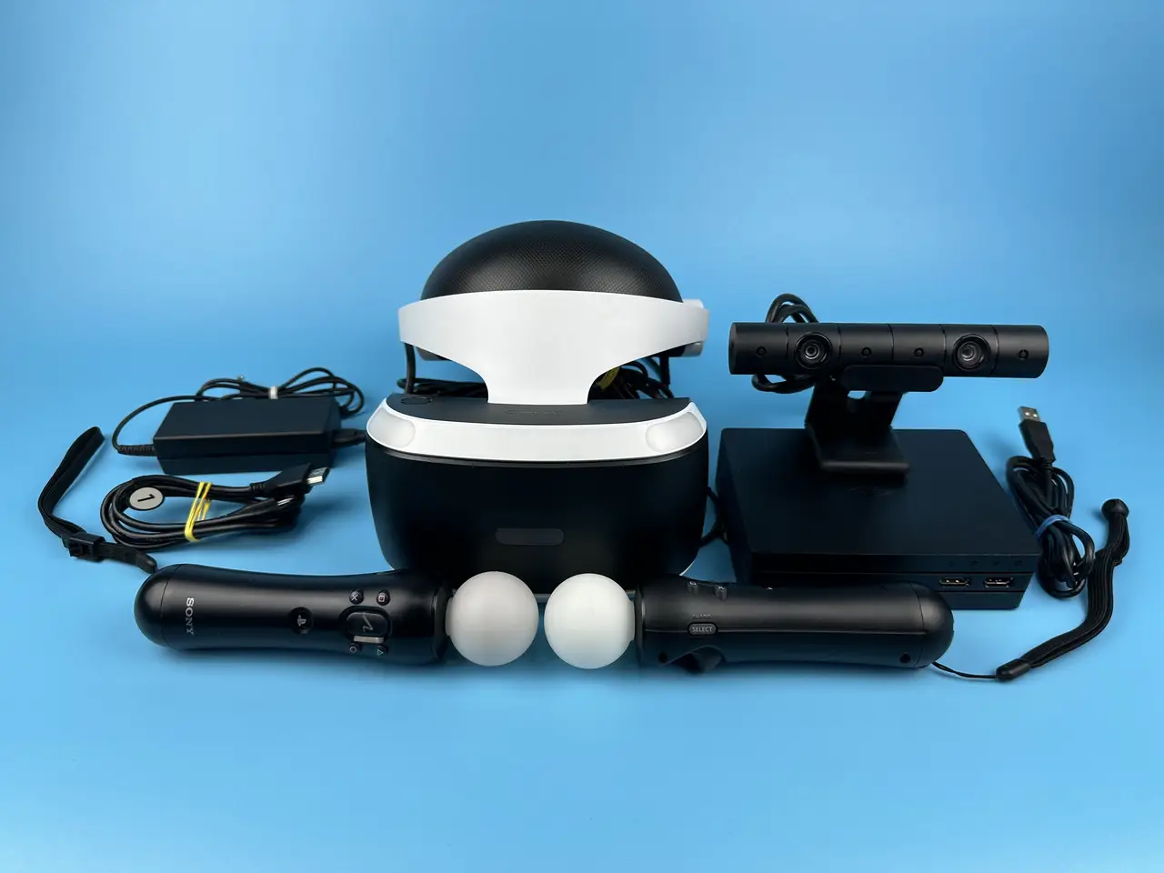 Комплект VR обладнання – набір віртуальної реальності з окулярами, контролерами руху, камерами відстеження та аксесуарами на синьому фоні
